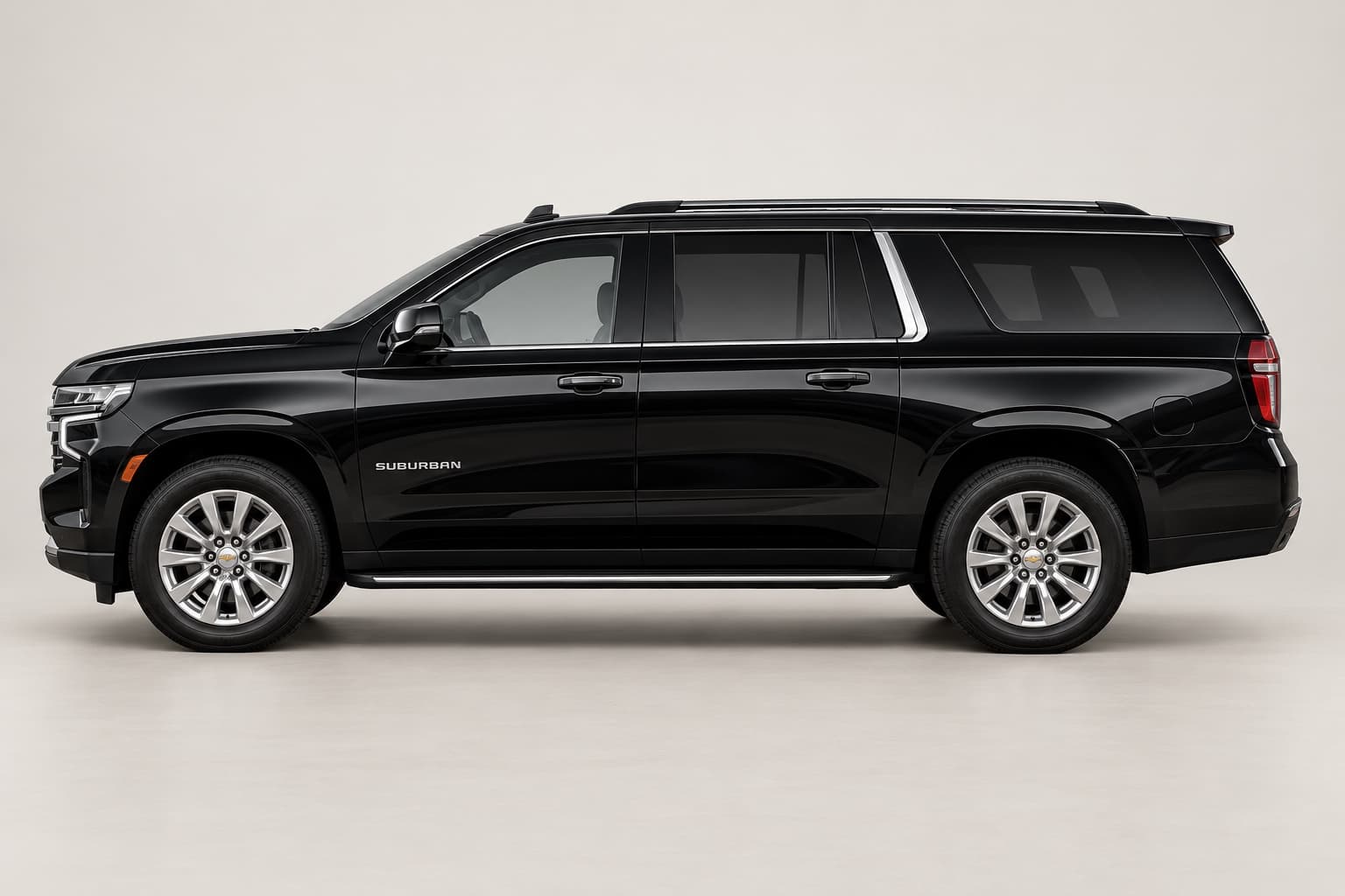 Black Chevrolet Suburban in side profile on a neutral studio background